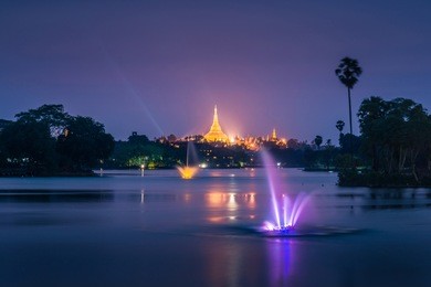 shwedagon pagoda seen at blue hour at the kandawgyi lake
