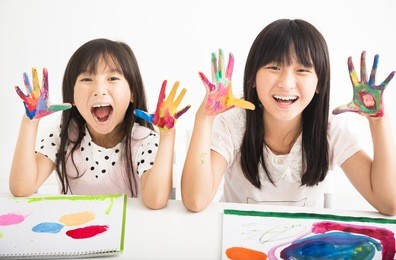 happy little girls with hands in the paint