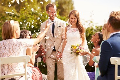 guests throwing confetti over bride and groom at wedding
