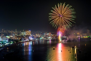 multicolor fireworks night scene, closeup with pattaya cityscape sea beach view, thailand