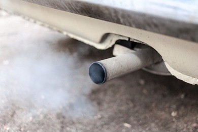 combustion fumes coming out of car exhaust pipe