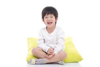 happy asian boy sitting on white background isolated