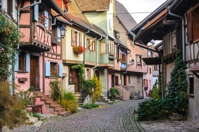 half-timbered houses on a narrow street in eguisheim, alsace, france