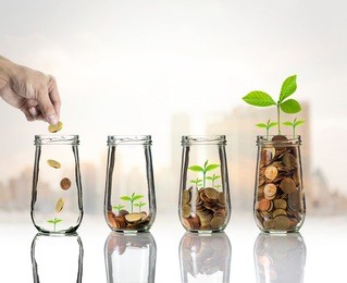 hand putting gold coins and seed in clear bottle on cityscape photo blurred cityscape background,business investment growth concept