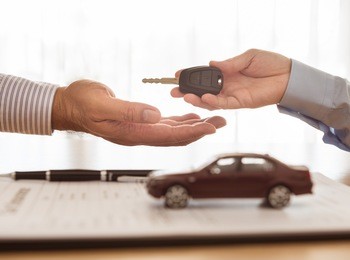 salesman sends the car keys to the client. concept of car insurance, rental, sales.