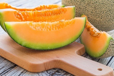 fresh melons sliced on wooden table