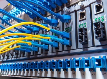 fiber optic cables connected to an optic ports and network cables connected to ethernet ports
