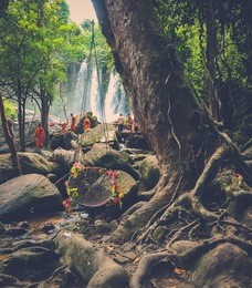 monks meditating at the tropical waterfall, phnom koulen, siem reap, cambodia