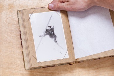 man holding a photo album with old photos
