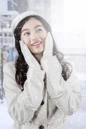 image of beautiful teenage girl with beauty pose and wearing winter coat in snowy day at the city