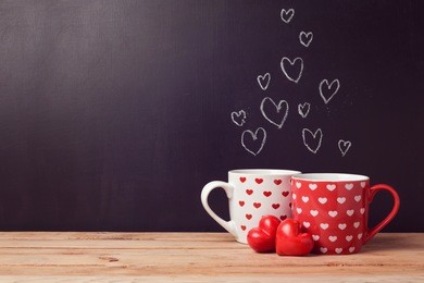 valentine's day concept with hearts and cups over chalkboard background