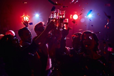 young friendly people toasting in night club