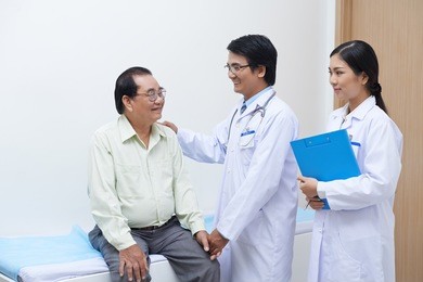 asian doctor encouraging senior patient after examination