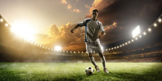 soccer player in action on sunset stadium background