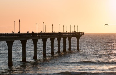 people fishing on new brighton pier at sunrise, christchurch, new zealand