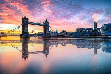 tower bridge with reflections at sunrise in london.