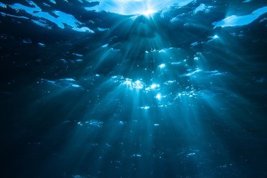 underwater shot with sun rays in deep blue tropical sea