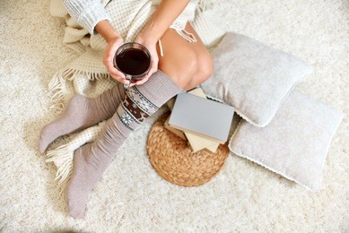 young beautiful woman in warm knitted handmade clothes at home. model fashion shooting. autumn, winter season. gaiters. golfs. leggings.