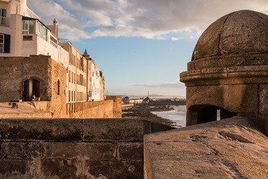 city fortification of essouira, morocco
early evening during golden hour. view on the houses on the coast in essaouira, morocco. mountain on the horizon. cloudy sky.