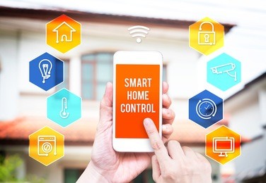 hand holding smart phone with home control application with blur home background, smart home concept.