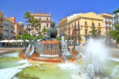 water flowing from the turia fountain on plaza de la virgen in valencia, spain
