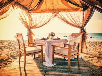 romantic dinner setting on the beach at sunset