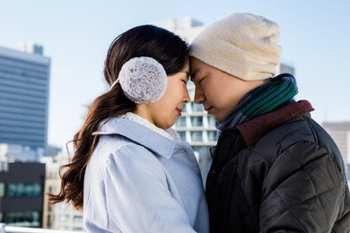 affectionate couple in warm clothing head to head