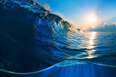 ocaen-view seascape landscape big surfing ocean wave with slightly cloudy sky and the sun