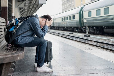 asian depressed traveler waiting at train station after mistakes a train.

