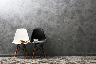 stylish conception with white and black chairs on grey background