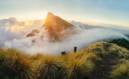 beautiful sunrise in the mountains. clouds flowing from one hill to valley. view on meesapulimala near kolukkumalai tea asstate in indian ghats