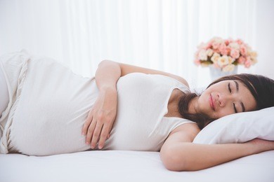 a portrait of a beautiful asian pregnant woman sleeping peacefully