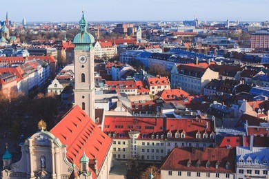 beautiful super wide-angle sunny aerial view of munich, bayern, bavaria, germany with skyline and scenery beyond the city, seen from the observation deck of st. peter church 