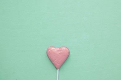 pink heart on mint green background. concept of love. pastel tone.