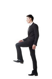 asian businessman walking up on stairs, full length portrait isolated 