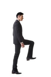 asian businessman walking up on stairs, full length portrait isolated 
