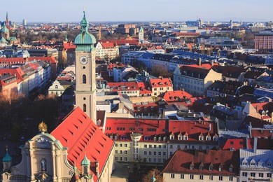 beautiful super wide-angle sunny aerial view of munich, bayern, bavaria, germany with skyline and scenery beyond the city, seen from the observation deck of st. peter church 