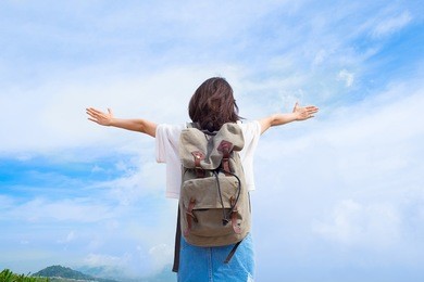 back side of traveler girl looking at the blue sky, travel and active lifestyle concept