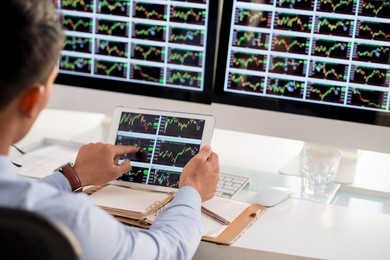 business broker analyzing stock market diagrams on the digital tablet
