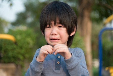 portrait of asian boy  crying in the park