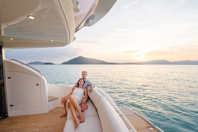 romantic vacation and luxury travel. young loving couple sitting on the sofa on the modern yacht deck. sailing the sea.