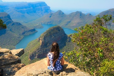 girl sitting on stone on the cliff in the blyde river canyon, south africa