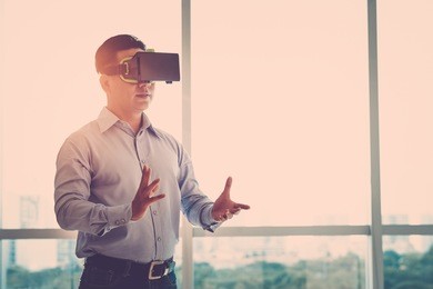businessman making gestures when wearing virtual reality goggles