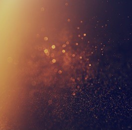 glitter vintage lights background. gold and black. defocused.
