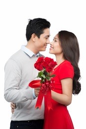 love is a great feeling! beautiful young loving couple bonding to each other while woman kissing her boyfriend holding bouquet of flowers