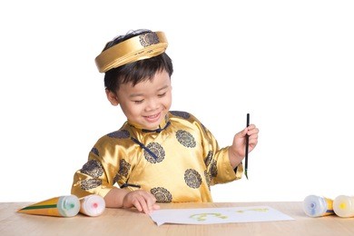 school asian boy in traditional dress ao dai learning with calligraphy at vietnamese lunar new year celebrating fair day organized.