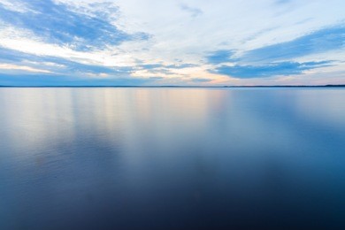 peaceful tranquil water landscape shot at long exposure with calm flat surface