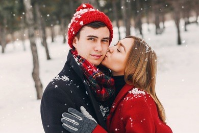 outdoor lifestyle portrait of young cheerful teen girl and guy  walking in winter time. hipster couple  in love hugging . valentines day. 