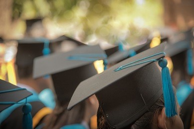 selective focus on graduation cap of front female graduate in commencement ceremony row