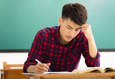 stressed student  studying for exam in classroom